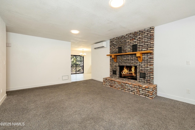 unfurnished living room featuring a wall unit AC, carpet, a brick fireplace, a textured ceiling, and an inviting chandelier