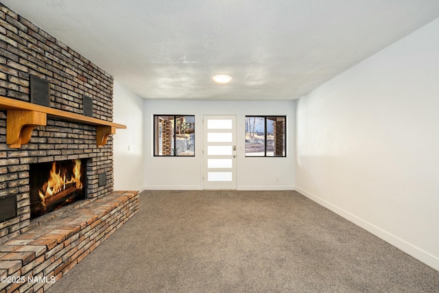 unfurnished living room featuring a brick fireplace and carpet floors