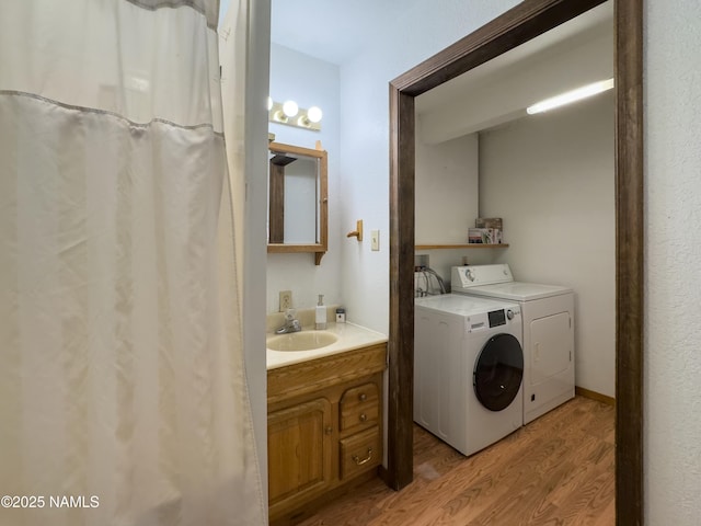 laundry area featuring sink, independent washer and dryer, and light hardwood / wood-style flooring