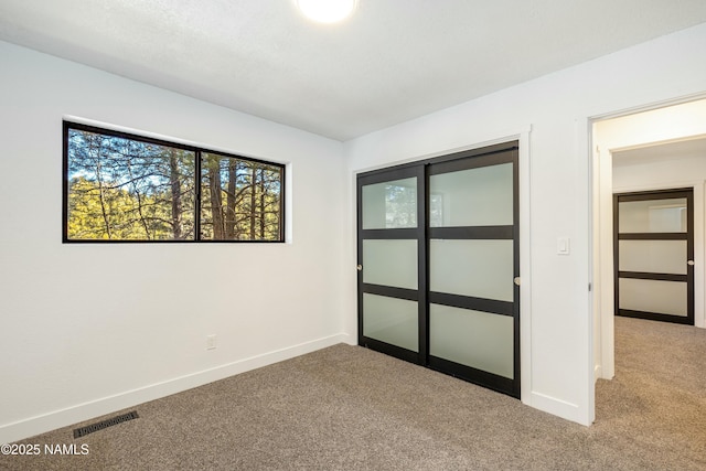 unfurnished bedroom featuring a closet and light carpet