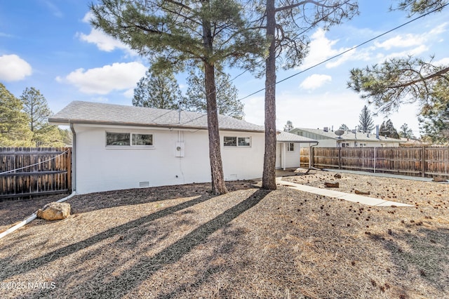 back of house featuring a shingled roof, crawl space, and a fenced backyard