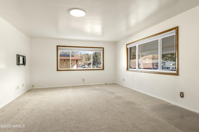 unfurnished room featuring carpet floors, a wealth of natural light, and baseboards