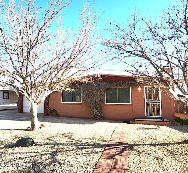 back of house with a garage and a chimney