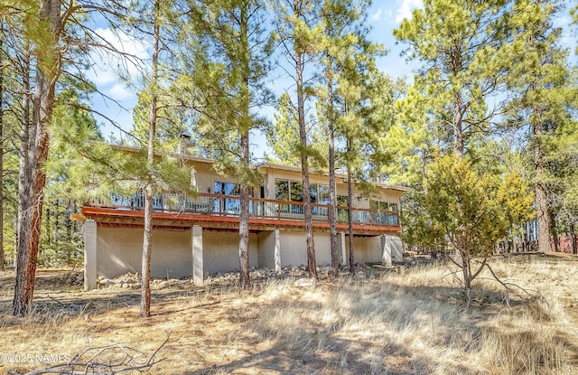 back of property with a chimney and a wooden deck