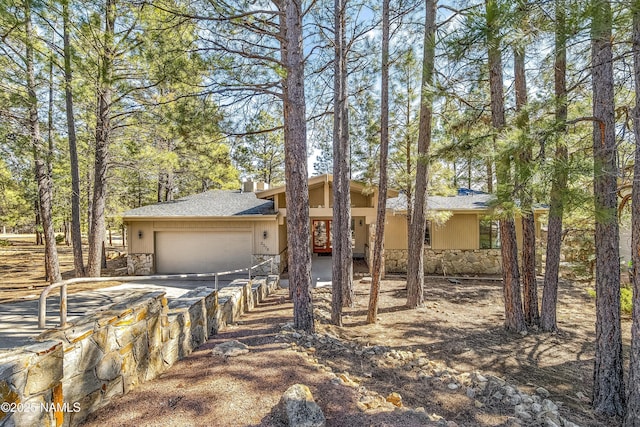 view of front of house featuring a garage and stone siding