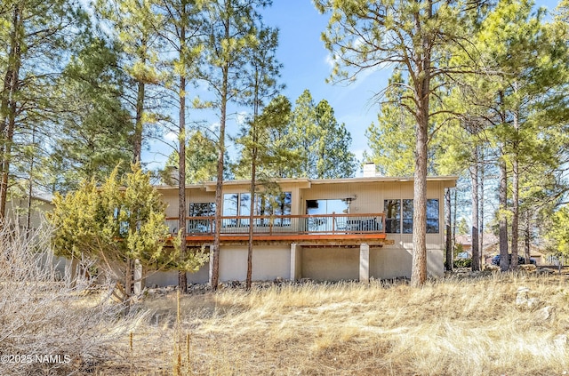 rear view of property with a deck and a chimney