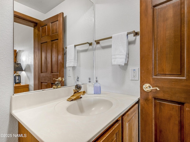 bathroom featuring a textured wall and vanity