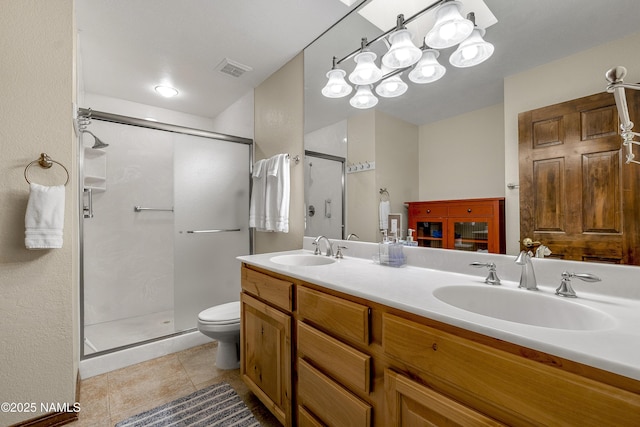 bathroom with a stall shower, tile patterned flooring, a sink, and visible vents