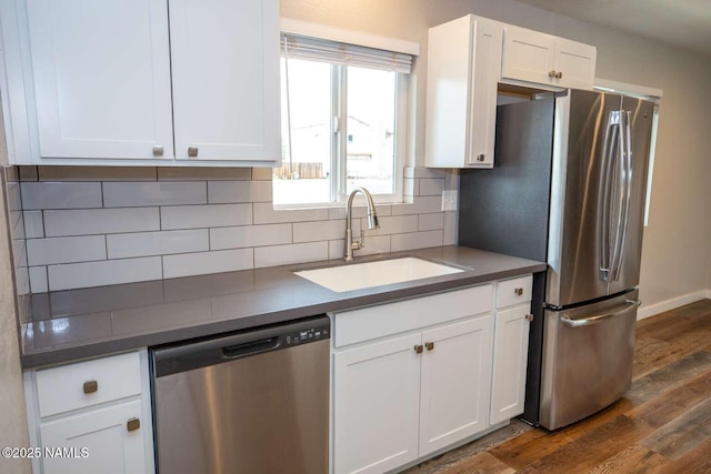 73 Seneca Dr, Flagstaff, AZ 86005 - kitchen featuring tasteful backsplash, stainless steel appliances, dark wood-type flooring, a sink, and white cabinets