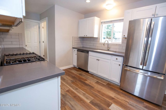 73 Seneca Dr, Flagstaff, AZ 86005 - kitchen featuring a sink, dark wood finished floors, stainless steel appliances, dark countertops, and decorative backsplash