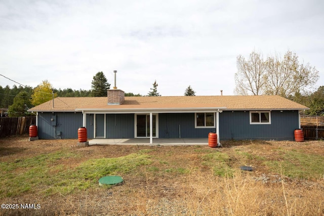 73 Seneca Dr, Flagstaff, AZ 86005 - back of house featuring a chimney, fence, and a patio area