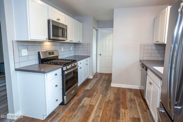 73 Seneca Dr, Flagstaff, AZ 86005 - kitchen featuring white cabinetry, appliances with stainless steel finishes, dark wood finished floors, baseboards, and dark countertops