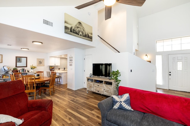 living room featuring ceiling fan, high vaulted ceiling, wood finished floors, and visible vents