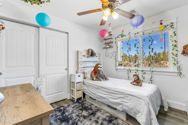 bedroom with dark wood-type flooring, a closet, and ceiling fan