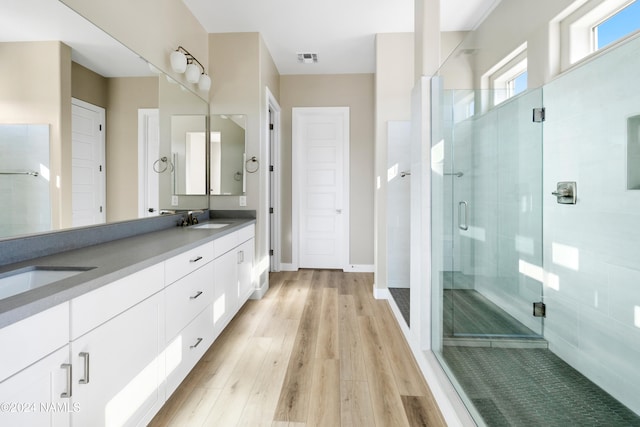 bathroom featuring hardwood / wood-style flooring, an enclosed shower, and vanity