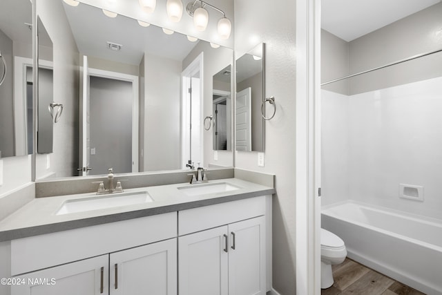 full bathroom with  shower combination, hardwood / wood-style flooring, toilet, and vanity