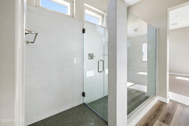 bathroom featuring hardwood / wood-style flooring and walk in shower