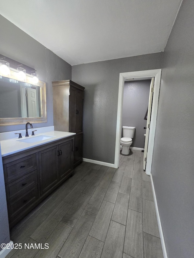 5895 Timberline Trl, Flagstaff, AZ 86004 - bathroom featuring vanity, baseboards, wood finished floors, and toilet