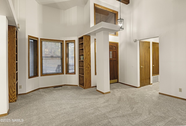 spare room featuring light carpet and a high ceiling