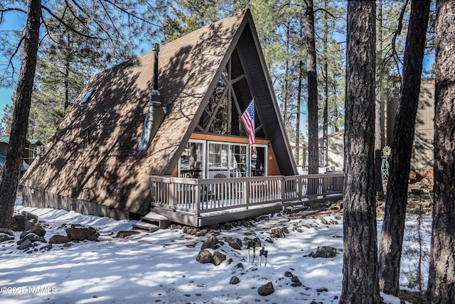 snow covered house featuring a deck