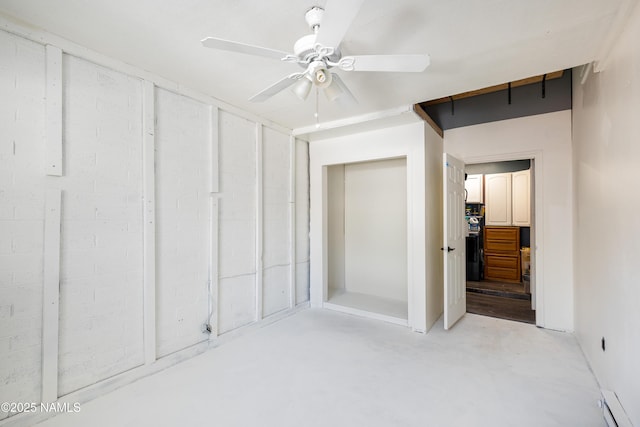 interior space with fridge, a baseboard heating unit, concrete floors, and ceiling fan