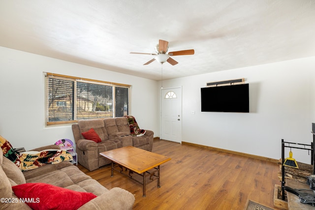 living room featuring baseboards, wood finished floors, and a ceiling fan