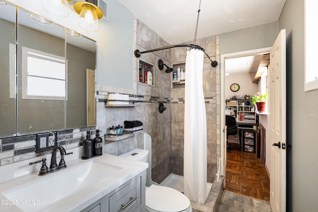 bathroom with a stall shower, toilet, and vanity