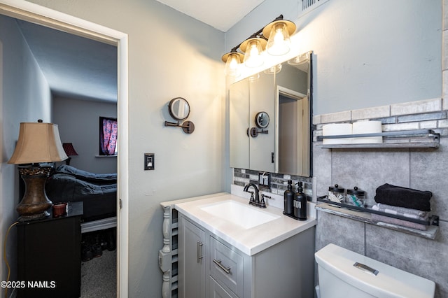 half bath featuring tasteful backsplash, vanity, and toilet