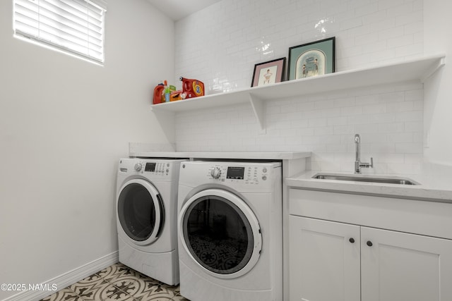 washroom featuring baseboards, light tile patterned flooring, cabinet space, a sink, and independent washer and dryer