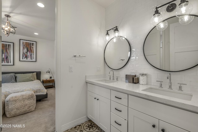 full bathroom featuring tasteful backsplash, connected bathroom, double vanity, and a sink