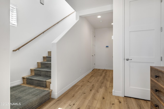 staircase featuring recessed lighting, baseboards, and hardwood / wood-style flooring