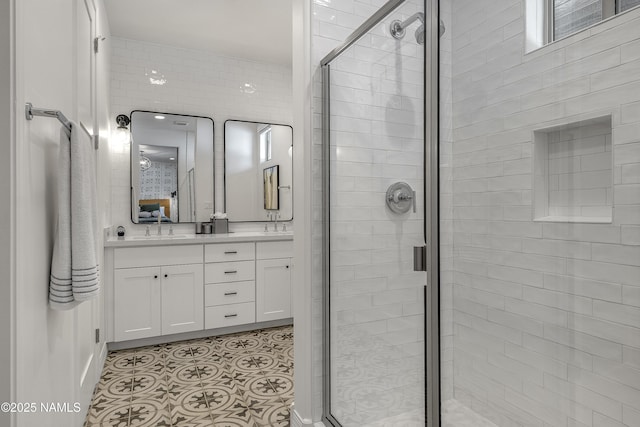 bathroom with tile patterned flooring, a shower stall, double vanity, and a sink