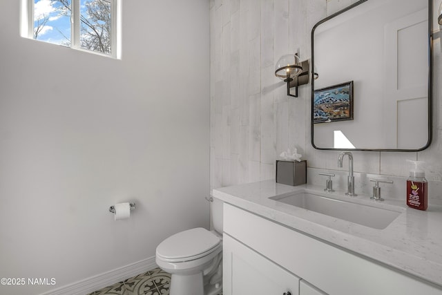 bathroom featuring baseboards, toilet, and vanity