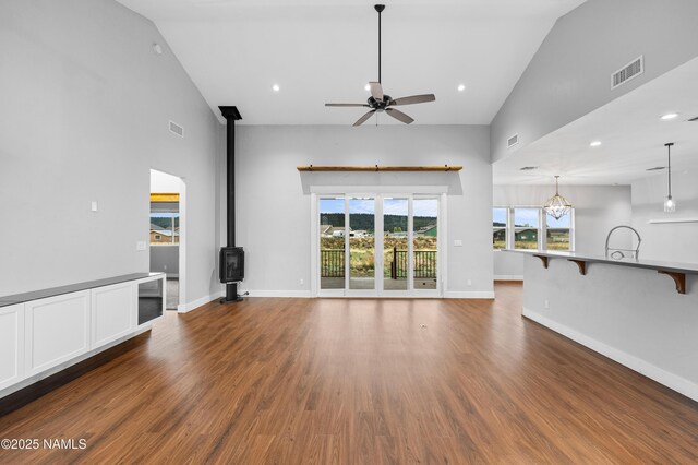 7497 W Dreamview Trl, Flagstaff, AZ 86001 - unfurnished living room with a ceiling fan, a wood stove, wood finished floors, baseboards, and recessed lighting
