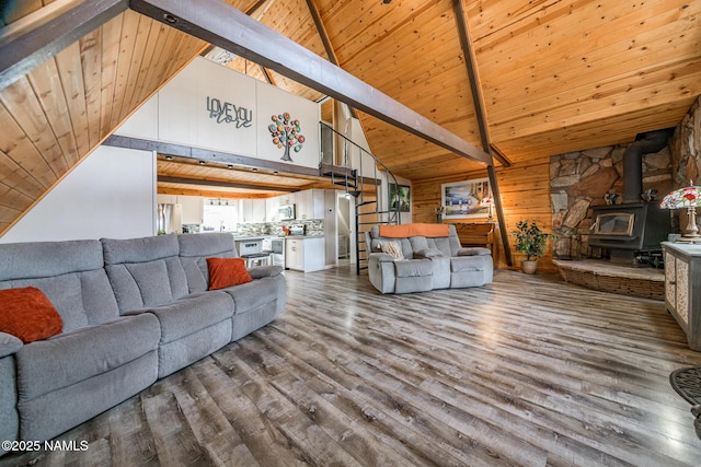 living area featuring beam ceiling, wooden walls, wood ceiling, and wood finished floors