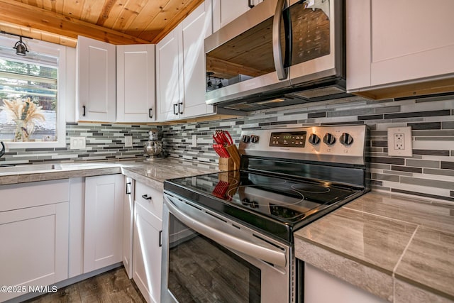 kitchen featuring white cabinetry, appliances with stainless steel finishes, light countertops, decorative backsplash, and wood ceiling