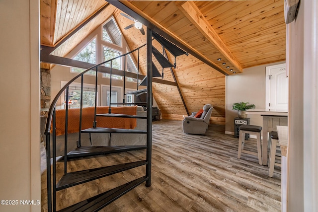 staircase with wood finished floors, beam ceiling, and wooden ceiling