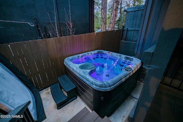 view of patio / terrace featuring a hot tub and fence