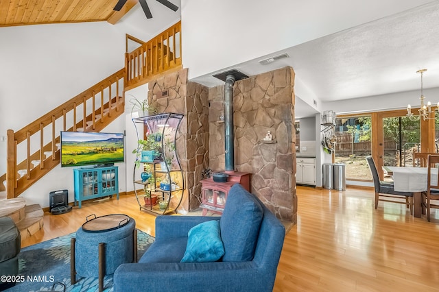 2606 N Fremont Blvd, Flagstaff, AZ 86001 - living area with stairway, a wood stove, wood finished floors, a chandelier, and a ceiling fan