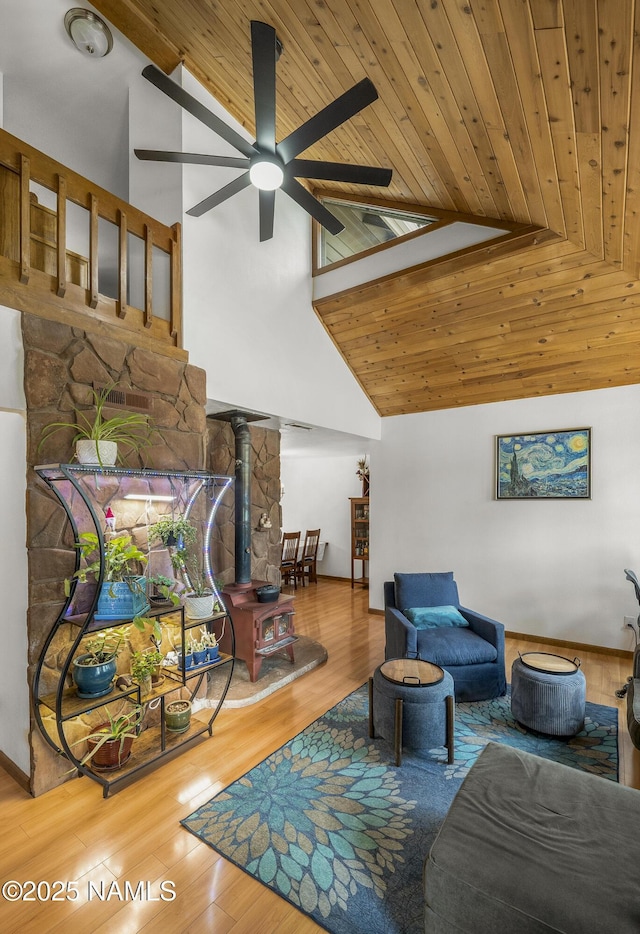 2606 N Fremont Blvd, Flagstaff, AZ 86001 - living room featuring a wood stove, ceiling fan, high vaulted ceiling, wood ceiling, and wood finished floors