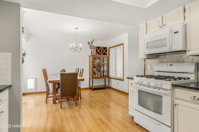 2606 N Fremont Blvd, Flagstaff, AZ 86001 - kitchen featuring white appliances, dark countertops, a chandelier, and light wood-type flooring