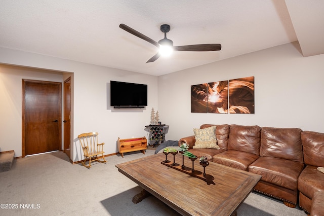 carpeted living area featuring ceiling fan and baseboards