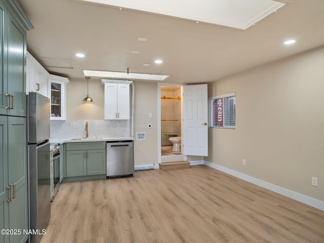 425 W Rte 66, Williams, AZ 86046 - kitchen featuring sink, light hardwood / wood-style flooring, appliances with stainless steel finishes, pendant lighting, and backsplash
