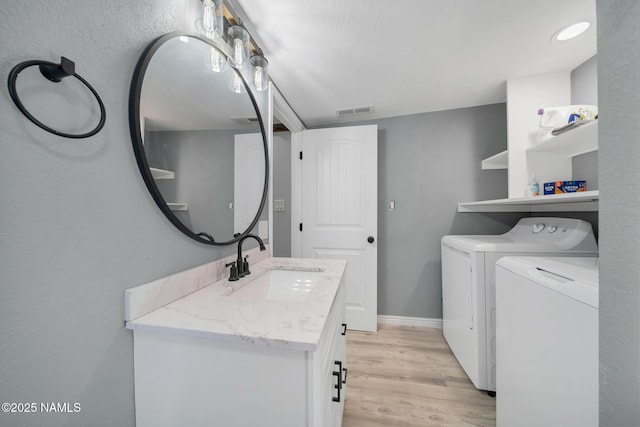 425 W Rte 66, Williams, AZ 86046 - laundry room with independent washer and dryer, cabinets, sink, and light hardwood / wood-style flooring