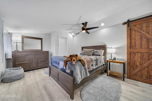 425 W Rte 66, Williams, AZ 86046 - bedroom with vaulted ceiling, a barn door, ceiling fan, and light hardwood / wood-style flooring