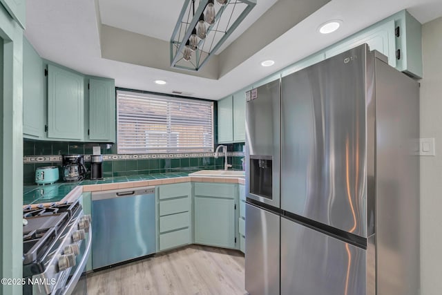 425 W Rte 66, Williams, AZ 86046 - kitchen with sink, light wood-type flooring, tile counters, stainless steel appliances, and backsplash