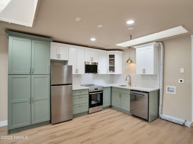 425 W Rte 66, Williams, AZ 86046 - kitchen with sink, appliances with stainless steel finishes, green cabinets, pendant lighting, and decorative backsplash
