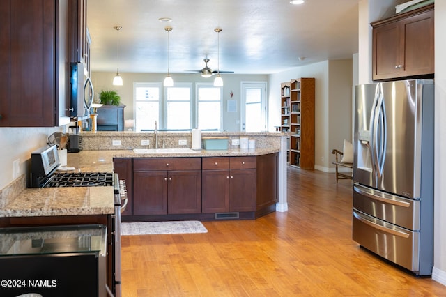 kitchen with light stone countertops, a wealth of natural light, sink, and stainless steel appliances