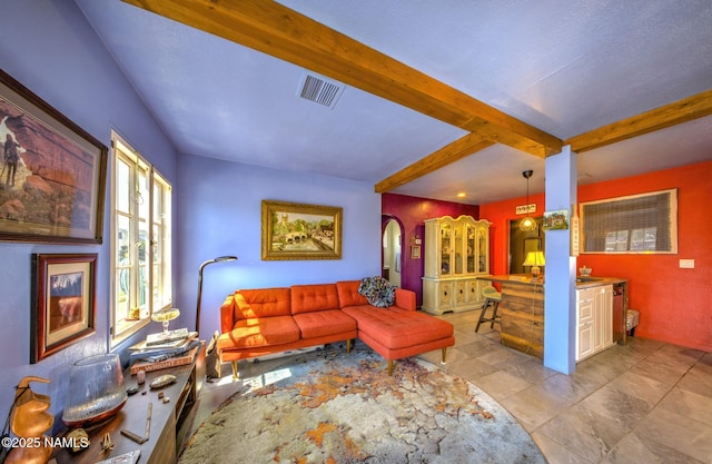 311 N Winslow Ave, Winslow, AZ 86047 - living area featuring beam ceiling, arched walkways, and light stone finish floors