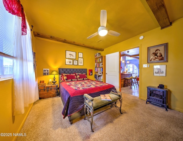 311 N Winslow Ave, Winslow, AZ 86047 - carpeted bedroom featuring a wood stove, baseboards, and a ceiling fan